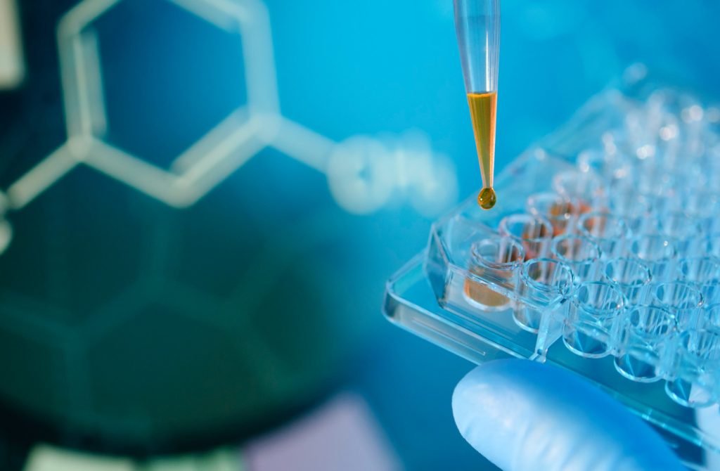 Lab technician injecting liquid into a microtiter plate